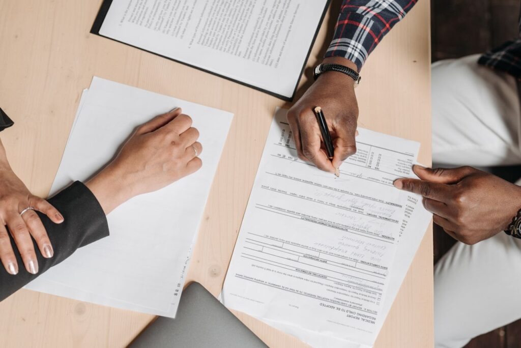 Pareja firmando documentos legales de inmigración en un escritorio